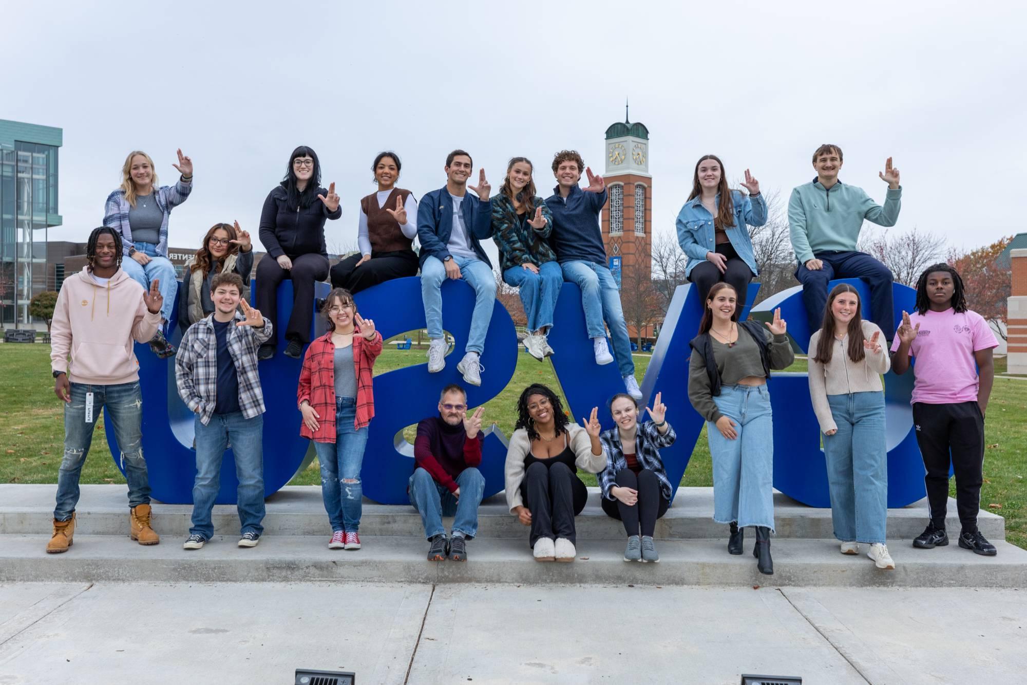 Student Senators holding the "Anchor-Up" hand signal in front of the GVSU letters.